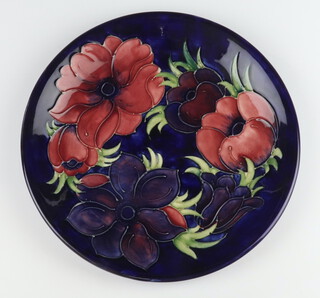 A Moorcroft plate decorated "Anemone", designed by Walter Moorcroft, signature and impressed mark 26cm 