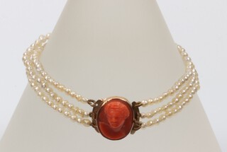 A 19th Century seed pearl triple strand bracelet with gilt metal mounted carved coral portrait clasp 14cm 