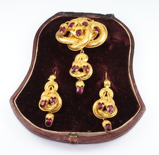 A Victorian gilt metal brooch and ensuite earrings in Etruscan mounts set with garnets in a fitted case 