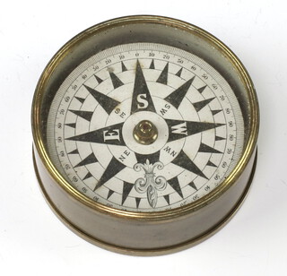 A compass with painted dial contained in a gilt metal case 3cm x 7cm