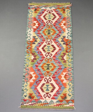 A yellow, turquoise and green ground Chobi Kilim runner with 5 stylised heptagons to the centre 158cm x 62cm 