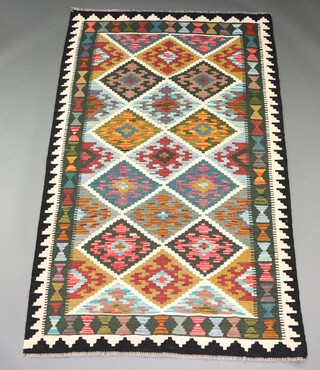 A black, white, tan and turquoise ground Chobi Kilim rug with overall diamond design 203cm x 126cm  