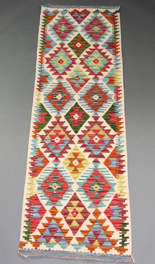 A white, tan and green ground Chobi Kilim runner with diamond design to the centre 196cm x 62cm 