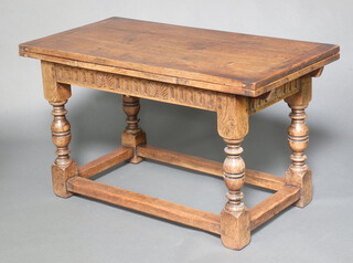 A 17th Century style carved oak draw leaf dining table with arcaded decoration, raised on cup and cover supports with box frame stretcher 77cm h x 132cm x 68cm 