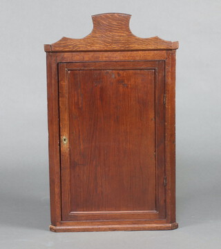 An 18th Century oak hanging corner cabinet, fitted a shelf enclosed by a panelled door 86cm h x 53cm w x 35cm 