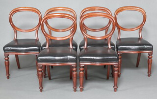 A set of 6 William IV mahogany balloon back dining chairs with overstuffed seats, upholstered in brown leather, raised on turned fluted supports  