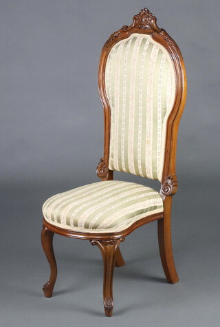 A Victorian carved mahogany show frame nursing chair upholstered in Regency stripe material, raised on cabriole supports 105cm h x 37cm w x 44cm d (seat 15cm x 20cm) 