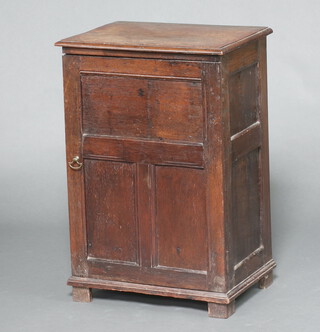 An oak cabinet formed from old timber, fitted shelves and a drawer, enclosed by a panelled door, raised on square supports 75cm h x 51cm w x 35cm d 