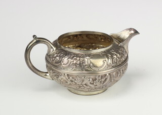 A Victorian repousse silver jug with scroll spout and floral scrolling decoration, London 1879, 119 grams 