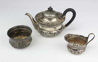 A Victorian repousse silver breakfast tea set comprising teapot with ebony mounts, cream jug and sugar bowl, Birmingham 1887, 332 grams gross 