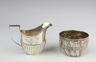 A Victorian repousse silver bowl with scroll decoration and vacant cartouche, London 1890 together with a demi-fluted cream jug Chester 1924, 177 grams 