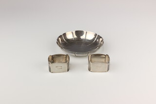 A silver scalloped dish London 1966 12.5cm, a pair of silver engine turned napkin rings Birmingham 1932, 170 grams 