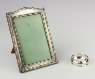 A silver arched top photograph frame Birmingham 1932 16cm x 11cm and a silver napkin ring