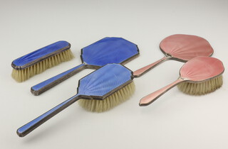 A silver and blue guilloche enamel hairbrush Birmingham 1941, a ditto mirror (bruised) and clothes brush together with a pink guilloche hair brush, clothes brush and mirror (both bruised)