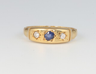 An 18ct yellow gold 2 stone diamond and sapphire ring, the diamonds each 0.04ct, the sapphire 0.05ct size M 1/2, 2.8 grams