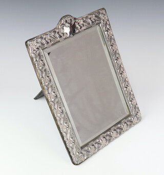 A Victorian style rectangular silver photograph frame with scrolling flowers and vacant cartouche London 1988, 37cm 