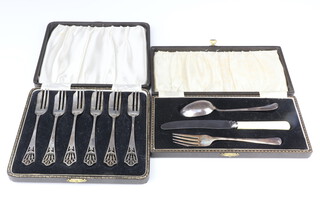 A set of 6 silver pastry forks with pierced handles Sheffield 1943 and a 3 piece christening set, weighable silver 154 grams, both cased 