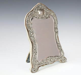 An Edwardian repousse silver serpentine shaped easel dressing table mirror with scroll decoration and vacant cartouche, Birmingham 1903, 31cm 