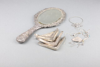 Four silver blotter corners, a coin bracelet and minor items, 66 grams, together with a repousse hand mirror 