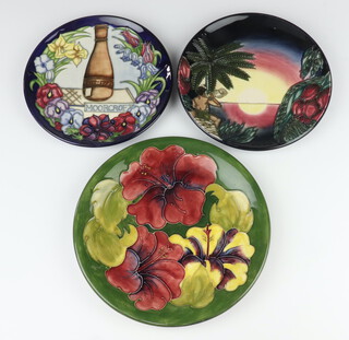 A Moorcroft Limited edition plate celebrating the Centenary of Moorcroft, the blue ground with flowers surrounding a bottle kiln and dated 1897-1997, designed by Rachel Bishop, no.118/750, dated '96, 22cm together with a Moorcroft plate decorated "Hibiscus" on a green ground designed by Walter Moorcroft, monogrammed and impressed marks 26.5cm and a Moorcroft Limited edition 2000 year plate (second), decorated "The Birth of Light" designed by Emma Bossons, no.762/2000, 23cm