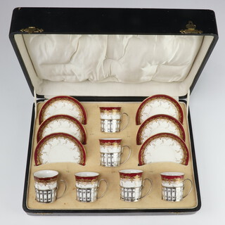 A Shelley coffee set with burgundy and gilt vinous decoration with silver cup holders Birmingham 1926, cased