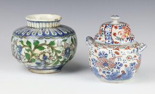 An Isnic baluster vase decorated with scrolling flowers (chip to rim) 15cm, together with a Delft style 2 handled jar and cover decorated with flowers 12cm (a/f) 