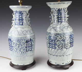 A pair of Chinese style blue and white table lamps in the form of urns with dragon handles 45cm h, complete with shades 