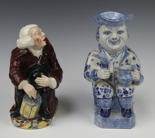 A 19th Century Dutch Delft Toby jug of a seated gentleman 24cm and a 19th Century English jug in the form of a seated gentleman with his right arm being the handle 22cm 