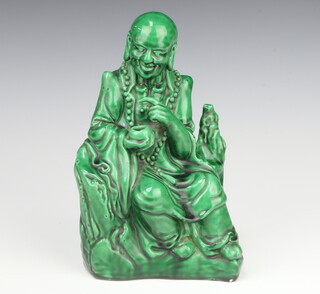 A 19th Century Chinese green glazed figure of a seated gentleman holding a pot 23cm 