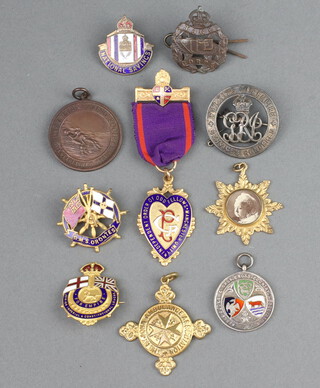 A First World War discharge badge numbered 320992, an Odd Fellows gilt and enamelled jewel, a Royal Life Saving Society bronze medal, a collar dog and a collection of badges 