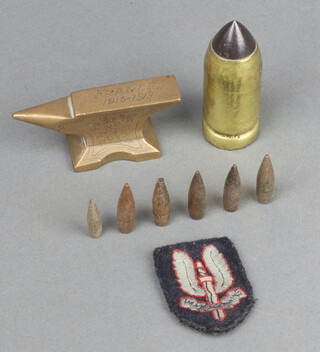 A SAS cloth badge 5cm x 3.5cm, various bullet heads, a brass miniature anvil marked France 1915-1990 4cm x 7cm 