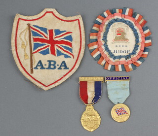 A 1934 British Empire Games gilt metal medal, a ditto British Empire Games Amateur Boxing medal marked Official, an Amateur Boxing Association blazer badge and a B.P.C.S Coronation Exhibition 1911 judges badge  