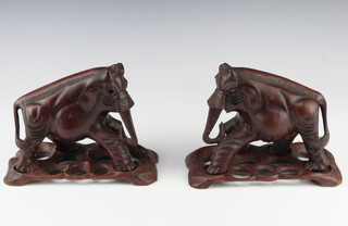 A pair of Eastern carved hardwood figures of elephants with hardstone eyes, raised on rectangular bases 19cm h 