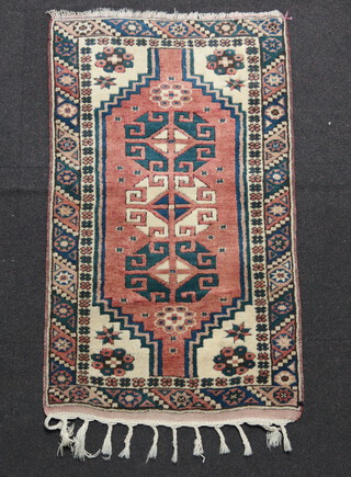 A white, blue and pink ground Afghan rug with 3 stylised diamonds to the centre 119cm x 69cm 