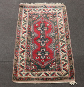 A red, green and brown ground Afghan rug with 3 medallions to the centre within a multi row border 193cm x 121cm 