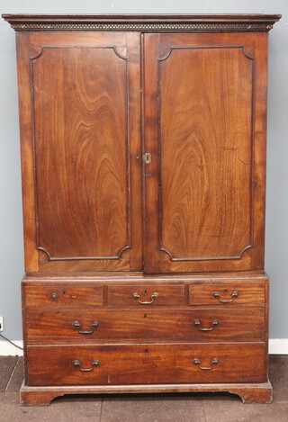 A Georgian mahogany linen press with Grecian key moulded cornice, fitted shelves enclosed by a pair of panelled doors, the base fitted 3 short and 2 long drawers, raised on bracket feet 190cm h x 126cm w x 65cm 