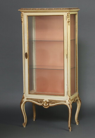 A French style cream and gilt painted display cabinet, fitted shelves enclosed by a glazed panelled door, raised on cabriole supports 149cm h x 67cm w x 35cm d 