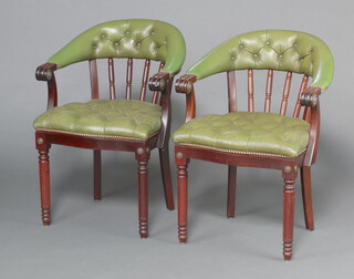 A pair of Georgian style mahogany tub back dining chairs with spindle decoration, the seats and backs upholstered in green buttoned leather, raised on turned and fluted supports 78cm h x 55cm w x 40cm d (seats 22cm x 26cm) 