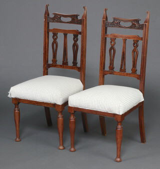 A pair of Edwardian carved and pierced mahogany stick and bar back dining chairs with upholstered overstuffed seats, raised on turned supports 106cm h x 45cm w x 40cm d 