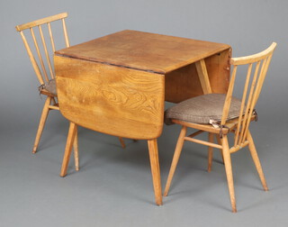 Ercol, a mid-Century elm and beech drop flap dining table, raised on outswept supports 71cm h x 61cm w x 75cm d, together with a pair of elm and beech stick and bar back dining chairs 78cm h x 42cm w x 36cm d  