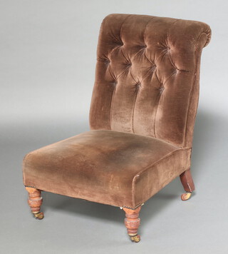 A Victorian nursing chair upholstered in brown buttoned material, raised on turned supports 81cm h x 59cm w x 60cm d 