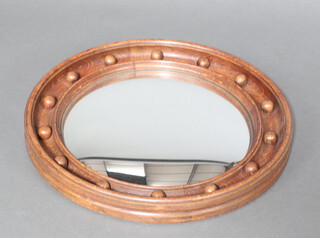 A Regency style circular convex plate mirror contained in an oak ball studded frame 47cm diam. 