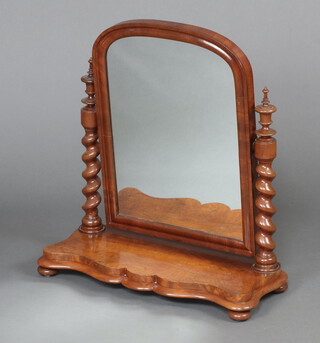 A Victorian arched plate dressing table mirror contained a mahogany framed supported by spiral turned columns, the base of serpentine outline 69cm h x 63cm w x 27cm d  