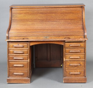 A 19th Century oak roll top desk, the interior fitted pigeon holes, the base with brushing slides and 8 drawers 129cm h x 137cm w x 90cm d  (no key)