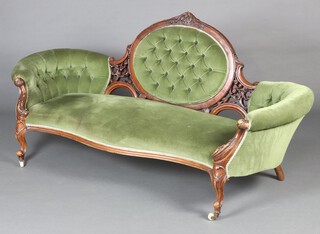 A Victorian carved mahogany show frame sofa, the seat and back upholstered in green buttoned material, raised on cabriole supports 89cm h x 190cm w x 61cm d (seat 120cm x 50cm) 