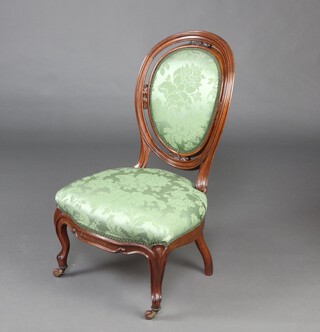 A Victorian mahogany balloon back nursing chair, the seat and back upholstered in green material, raised on cabriole supports 91cm h x 49cm w x 46cm d (seat 27cm x 37cm) 