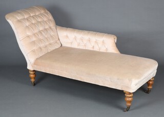 A Victorian chaise longue upholstered in mushroom coloured buttoned material, raised on turned supports, brass caps and casters 184cm h x 199cm w x 63cm d (seat 114cm x 35cm) 