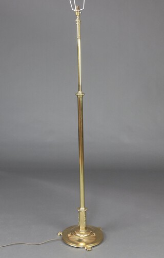 A Victorian style brass standard lamp, raised on a circular base with scroll 146cm h x 28cm (This lamp is a PAT TEST fail and is only sold for decorative purposes)