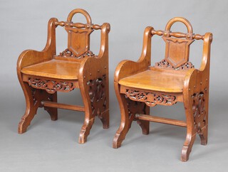 A pair of Victorian Gothic pierced oak hall chairs in the manner of Richard Bridgens with shield shaped slat backs, solid seats and pierced panels to the sides 77cm h x 48cm w x 36cm d (seat 26cm x 28cm) 