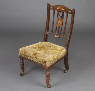 An Edwardian inlaid mahogany slat and bar back nursing chair upholstered in yellow material, raised on turned supports 78cm h x 43cm w x 38cm d 